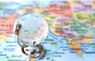 世界地図を前に地球儀で臨むイメージ